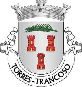 Brasão heráldico com coroa e torres vermelhas, encimado por ramo de palma verde e ladeado por dois símbolos em forma de rolos.