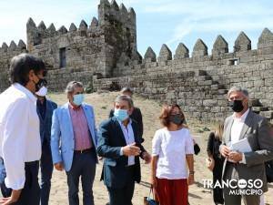 Grupo de cinco pessoas em visita oficial junto à muralha medieval de Trancoso, algumas com máscara facial.