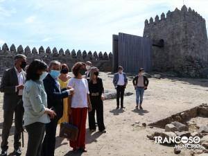 Grupo de pessoas em comitiva dentro das muralhas do castelo de Trancoso, com fortificações medievais ao fundo